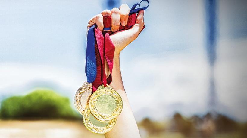 Hand of female athlete holding gold medals